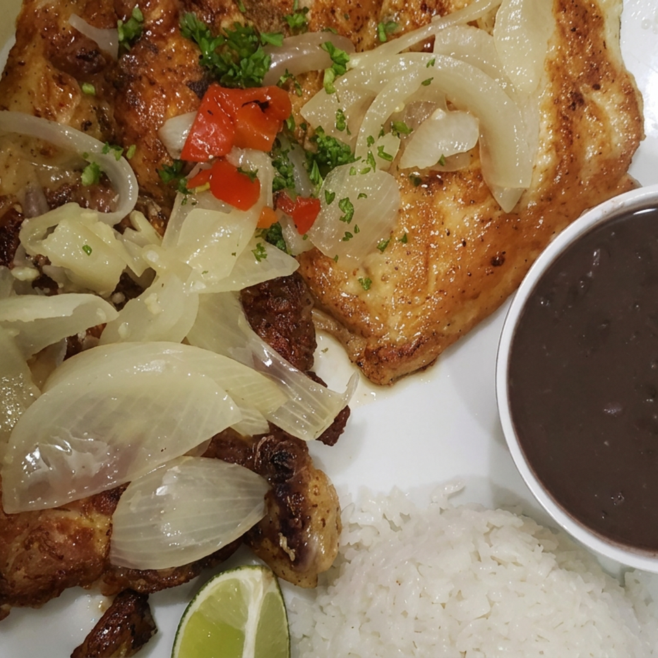 Grilled chicken topped with sautéed onions, peppers, and herbs, served with white rice, lime, and black beans.